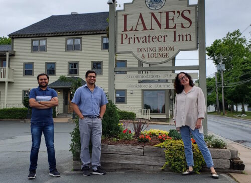 Manager Milan Virani, New Owner Ankur Viirani and Susan Lane stand outside Lane's Privateer Inn