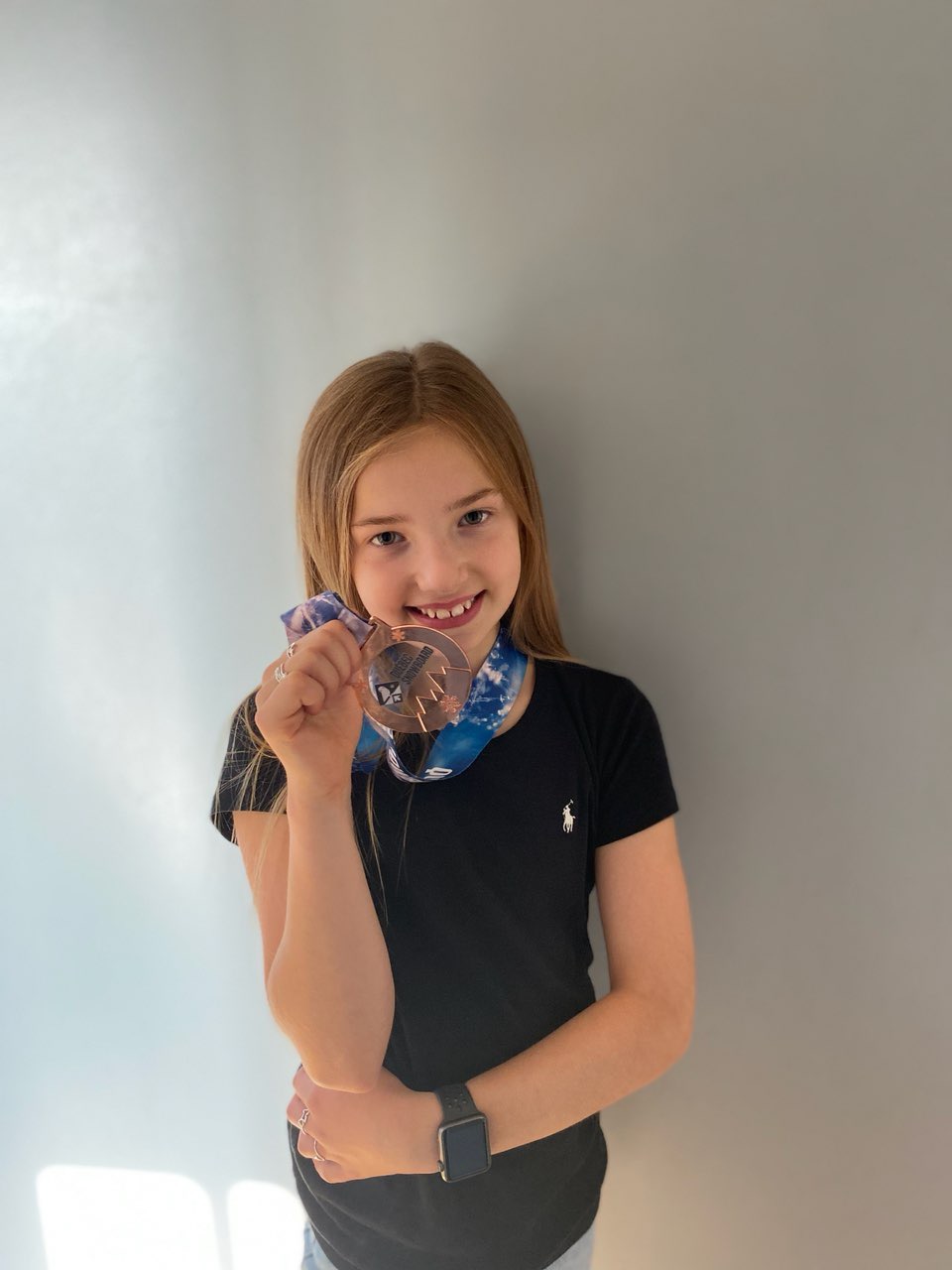 Jeune fille tenant la médaille de bronze de la Coupe Québec