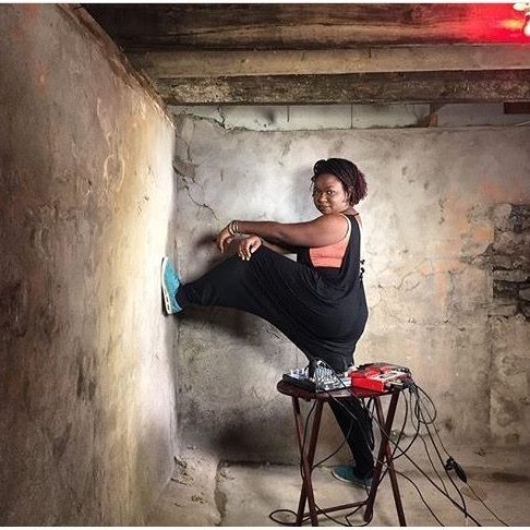 Elena Stoodly posant dans une cave, pied gauche sur le mur et les bras croisés.