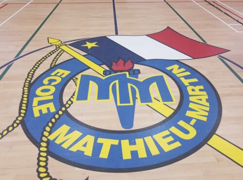 Le logo de l'école Mathieu-Martin sur le plancher du gymnase