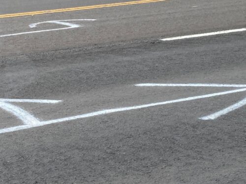 White, temporary arrows painted on the pavement at Exit 22A along Highway 103