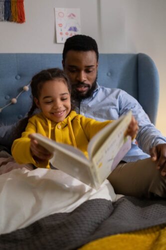 Père et enfant qui font de la lecture.
