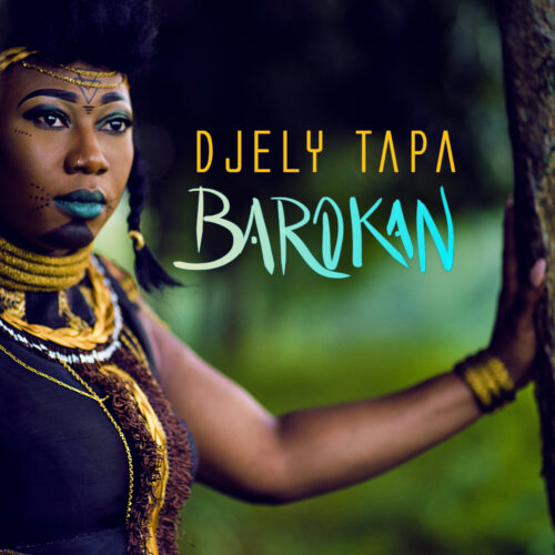 Djely Tapa en tenue africaine , robe marron et colliers multiples , maquillage de scène prise à l'extérieur