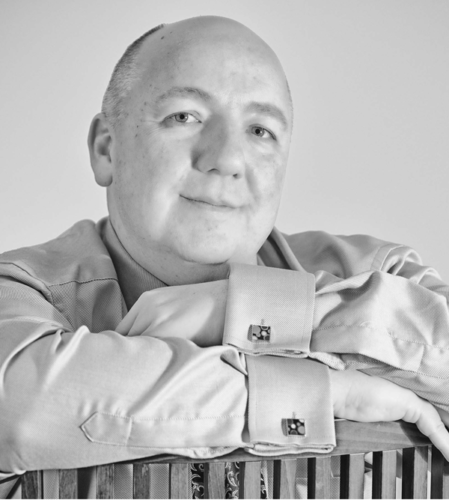 Jim Schneider leaning on a chair, black and white image