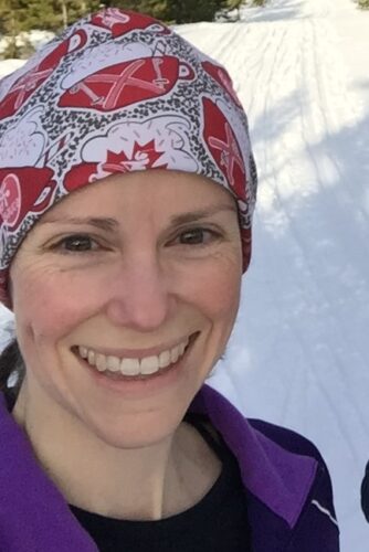 a woman in a headband smiling, snowy background