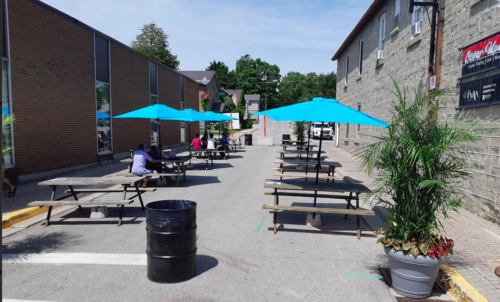 Provost Lane in downtown Fergus is seen with blue umbrellas at park benches and tables on a sunny day