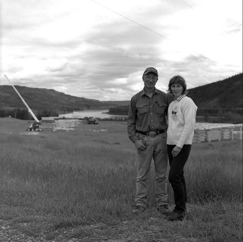 blakc and white image of couple standing on farmland