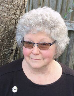 Portrait d'une dame aux cheveux grisonnants et lunettes teintées