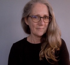 portrait d'une femme au long cheveux blonds, lunettes et pull noirs