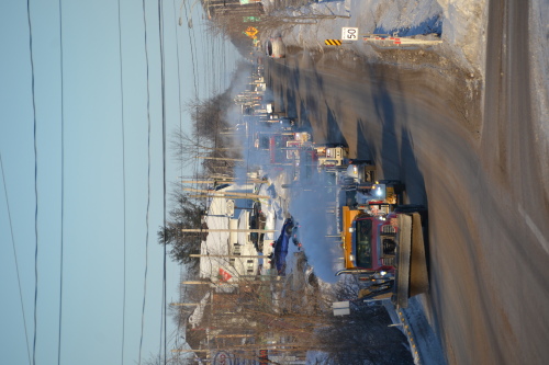 A convoy of about a dozen big rigs, led by a snowplow truck, head out of Shawville on the highway.