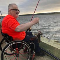 Homme dans une chaise roulante à la pêche.