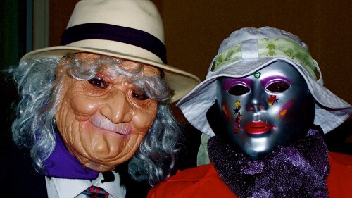 Deux personnes costumées avec masques, chapeaux et costumes.