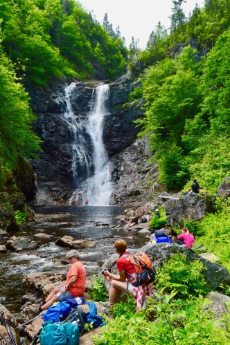 Des gens admirant une chute d'eau par une belle journée d'été.