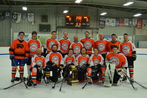 The Micksburg Bulls, wearing orange and white jerseys, pose for a team picture on the ice after winning the A Division final.