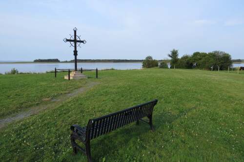 Un banc et une croix commémorative dans un champ.