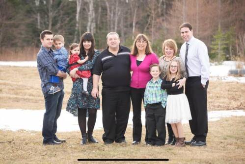 Les parents au centre avec leurs deux fils et leurs familles rassemblés dans un champ.