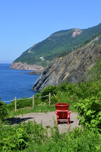 Une chaise rouge à côté d'une falaise.