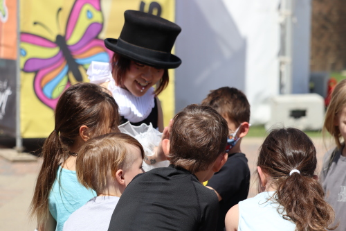 Image shows Children interacting with festival performer