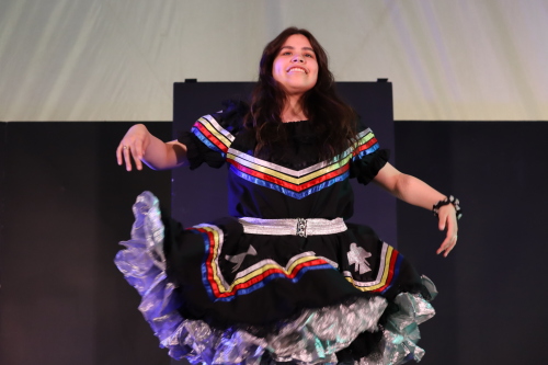 Image shows Cieanna Harris performing at event. Sheis dancing in front of a black and white background on stage.