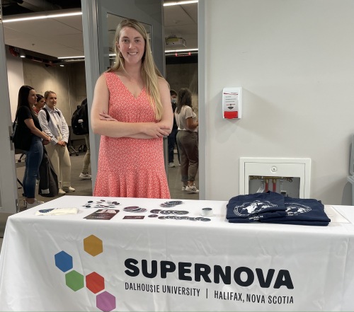 Executive director Alexandra Fenton with SuperNOVA shirts, badges and stickers merchandise.