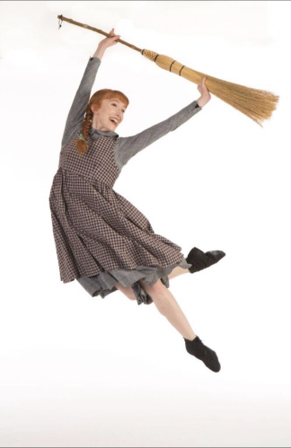 Hannah Mae Cruddas is seen dressed as Anne Shirley and dancing with a broom stick, in two braids.