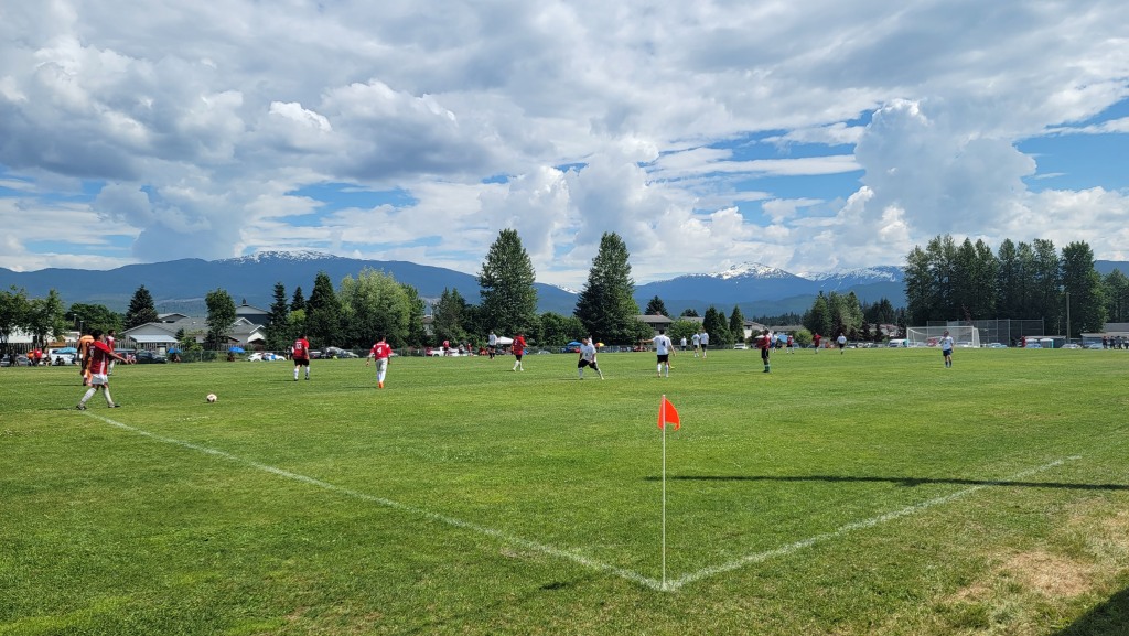 two soccer teams in red and white shirts on a soccer field 