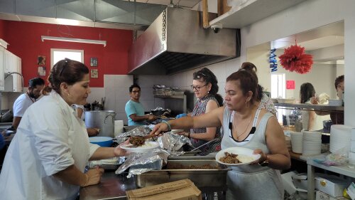 Personas en una cocina sirviendo platos