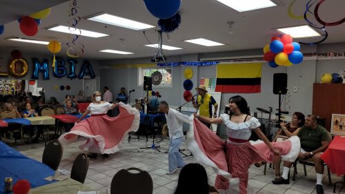 Dos mujeres y un hombre bailan.