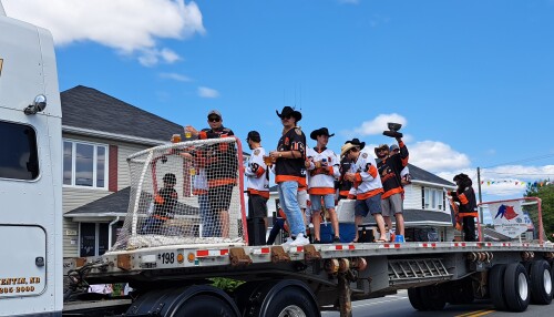 Des joueurs de hockey célèbrent leur victoire de championnat sur une remorque, lors d'un défilé