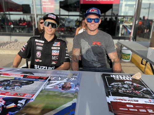 A photo of the two super race stars Alex Dumas and Trevor Daley signing autographs at Pro Cycle Dartmouth. 