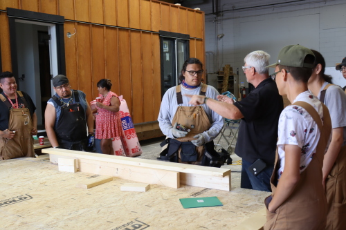 Students working with wood planks at the Residential Constriction Program inside a Trade Winds to Success building