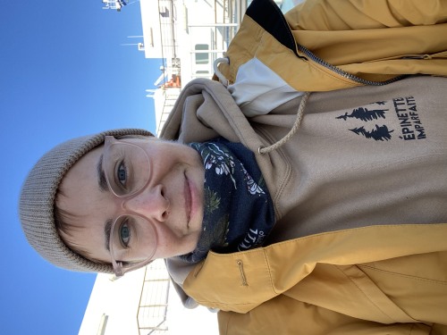 Portrait d'une femme habillée d'un manteau et d'un foulard sur un bateau.