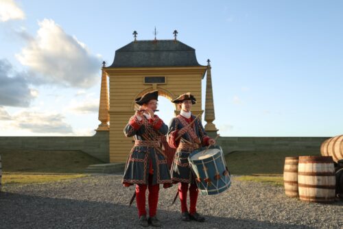 Deux jeunes en costumes d'époque jouant de la musique.