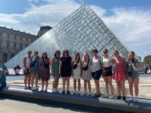 Des filles en avant d'une pyramide.