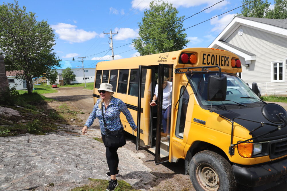 Une dame sort d'un minibus.