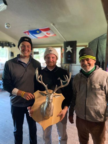 Trois hommes portant une tuque tiennent leur trophée après avoir remporté un tournoi de golf 