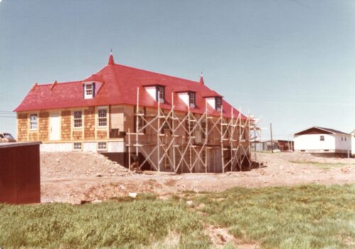 Un édifice en bois en construction avec un toit rouge.