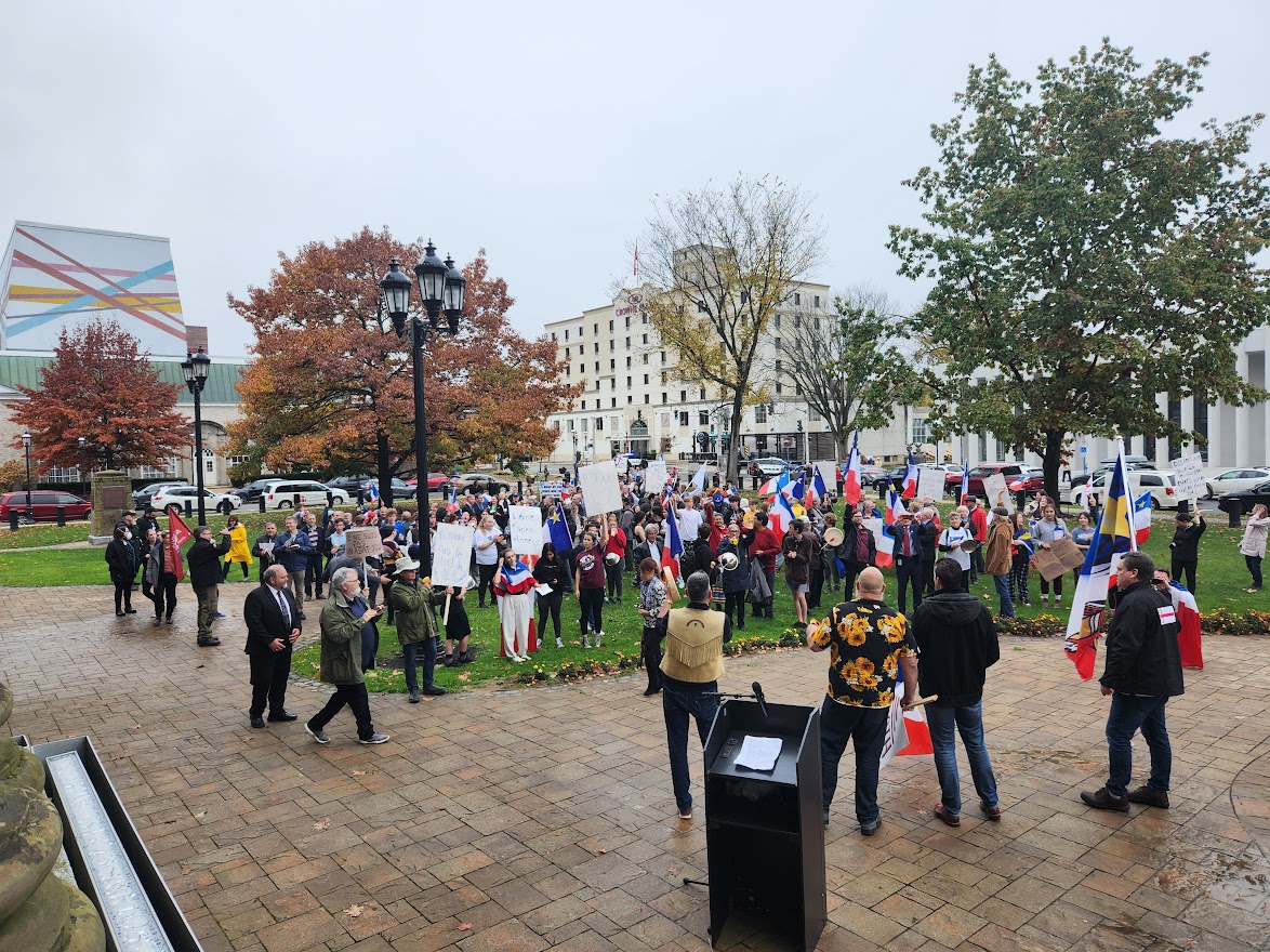 On vois la foule se masser devant l'assemblée législative du Nouveau-Brunswick.