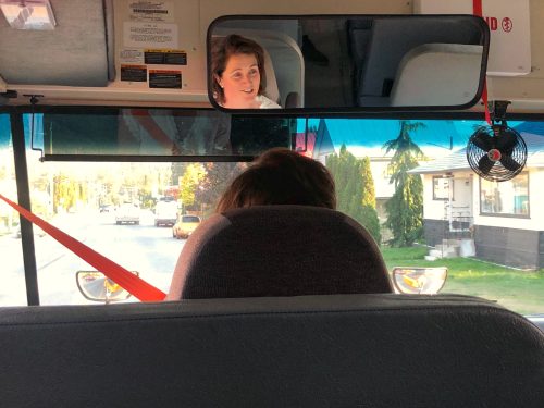 Person driving with their face in the mirror.
