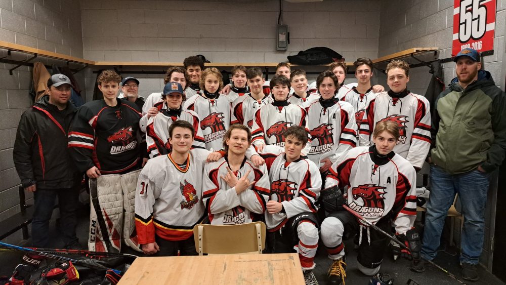 Équipe de hockey en uniforme blanc et rouge dans le vestiaire en position pour une photo d'équipe
