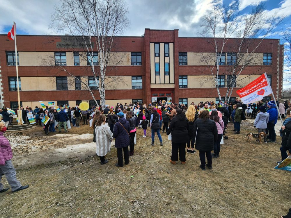 On vois une foule réunie devant le batiment de l'école élémentaire Nashwaaksis Memorial