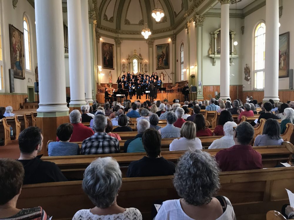 Des gens assis regardant la chorale performée