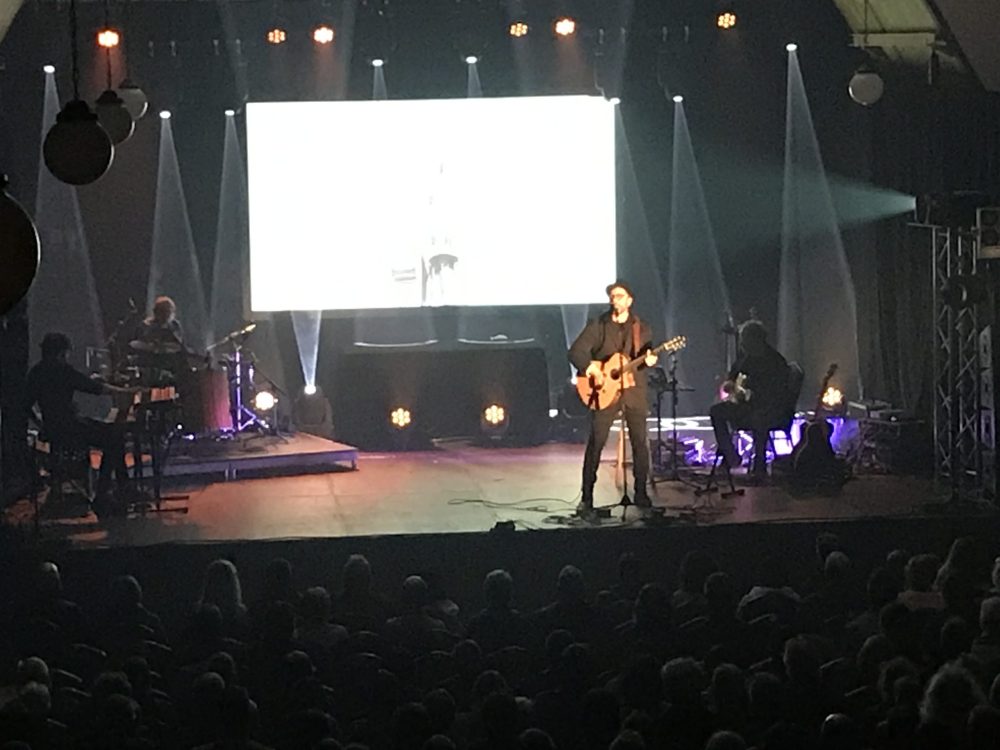 Des musiciens sur scène en prestation devant une foule attentive