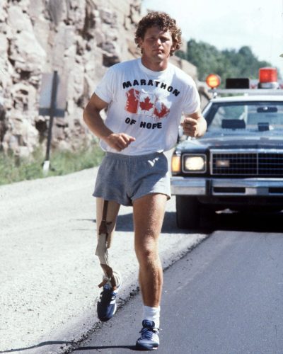 Un jeune homme avec une jambe amputée court en avant d'une voiture de police.