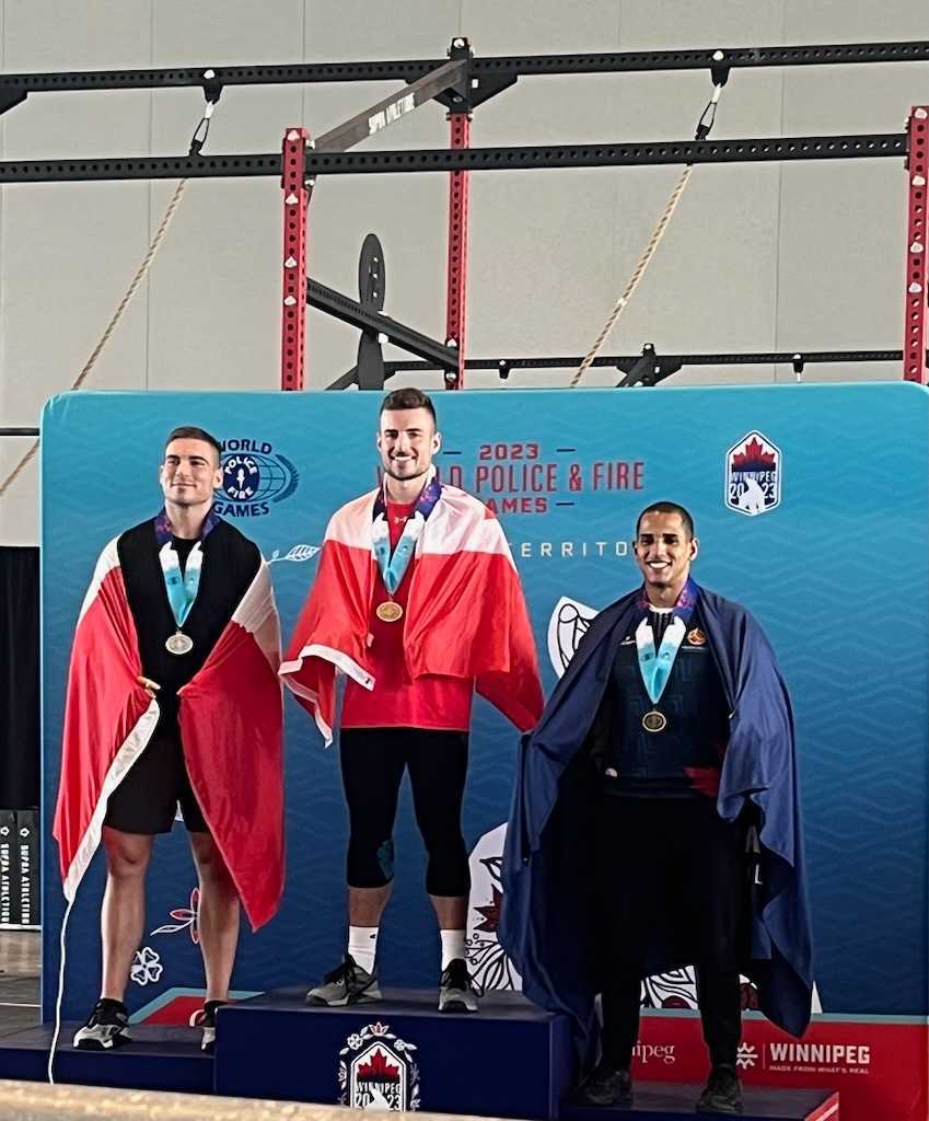 Trois athlètes de CrossFit sur un podium à la suite d'une compétition de Cross-Fit