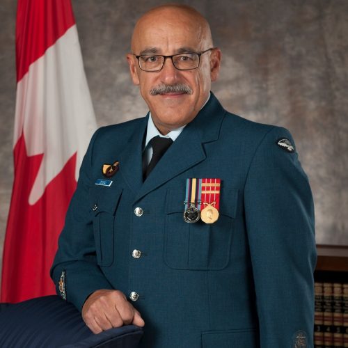Un homme militaire en avant du drapeau du Canada.
