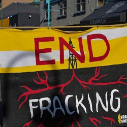 Protesters carry a banner reading End Fracking