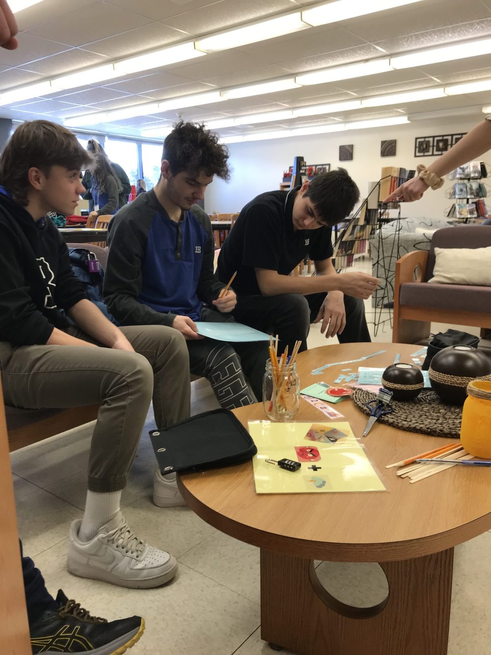 Trois jeunes garçons assis près d'une table avec des instruments à dessin