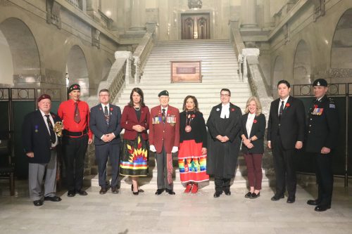 Dignitaries from the Government of Alberta in the Alberta Legislature rotunda recognizing Indigenous Veterans Day. Photo was taken inside, the lighting was bright which creates a fog-like effect in the background.