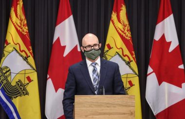 Dr. Dow stands behind a podium and is wearing a mask.